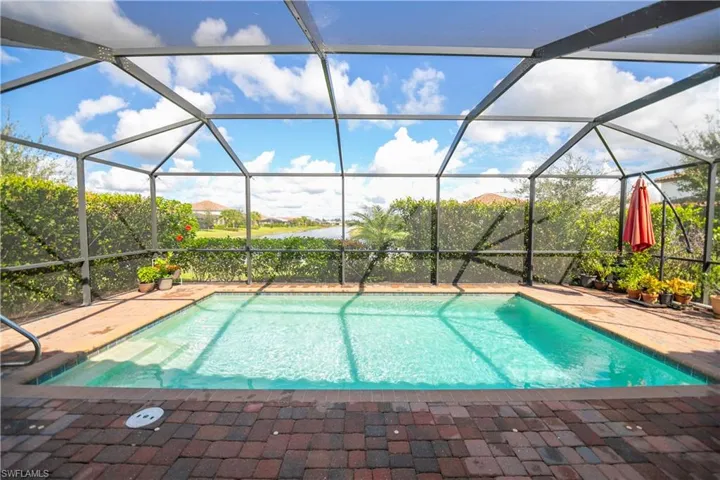 Outdoor pool featuring a sunroom and glass enclosure