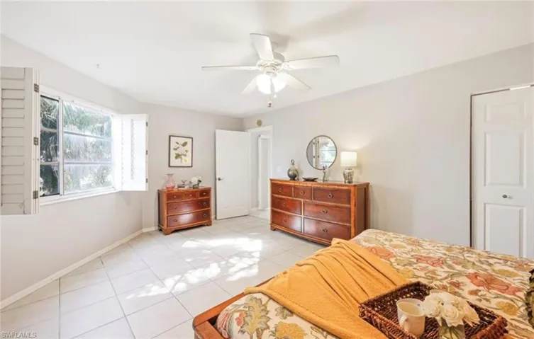 Bedroom featuring a ceiling fan, baseboards, and light tile patterned floors