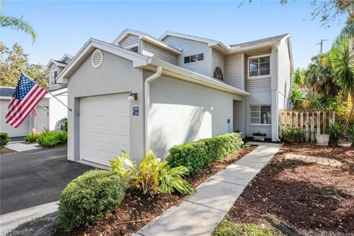 Multi unit property with stucco siding, fence, aphalt driveway, and a garage