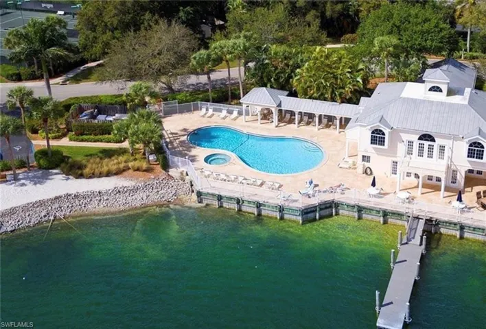 Community pool with a patio area, a gazebo, a water view, and a boat dock