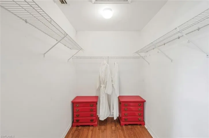 Walk in closet featuring wood finished floors and visible vents