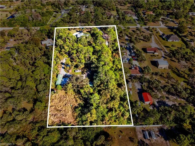 Aerial view of property and surrounding area featuring property parcel outlined
