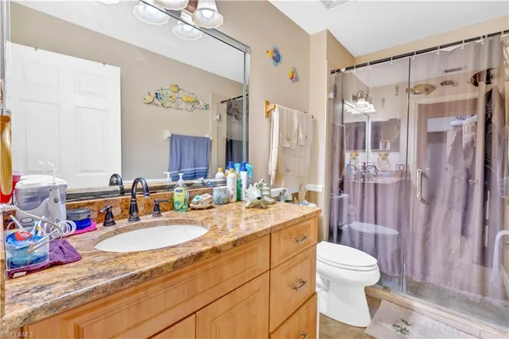 Bathroom featuring a shower stall and vanity