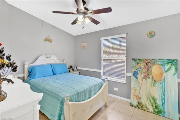 Bedroom with a ceiling fan and light tile patterned floors