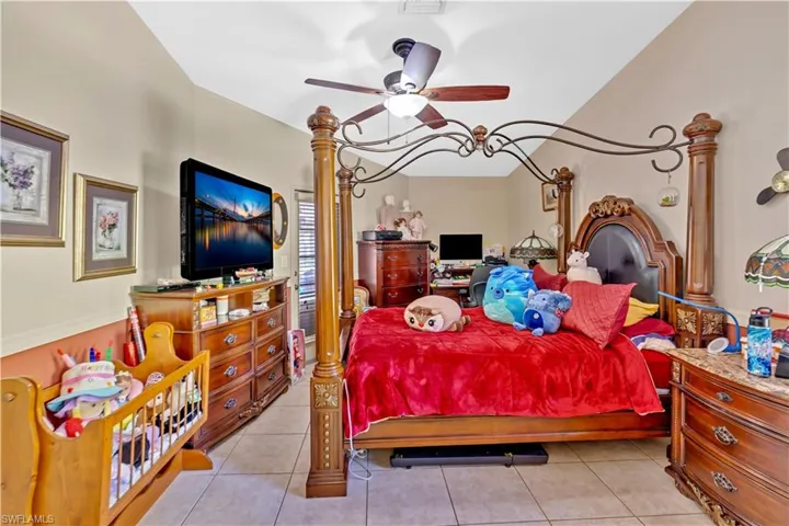 Bedroom with light tile patterned floors and a ceiling fan