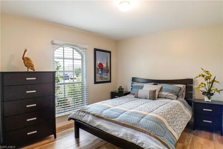 Bedroom featuring multiple windows and light hardwood / wood-style flooring