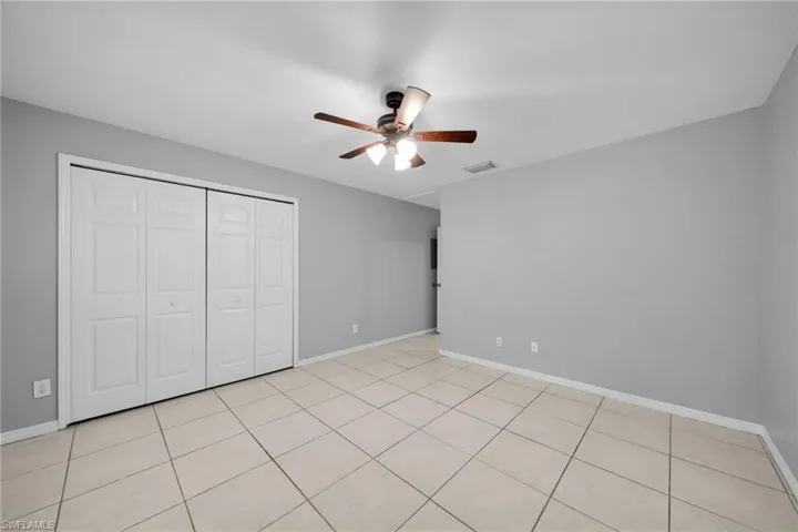 Spacious room featuring neutral grey walls and light-toned tile flooring