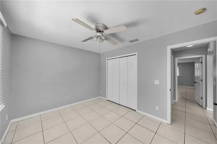 Room featuring light gray walls, white baseboards, and neutral square tile flooring