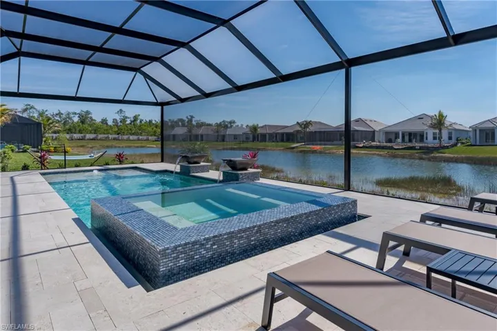 View of pool featuring an in-ground hot tub, an infinity pool, a patio area, and a water view