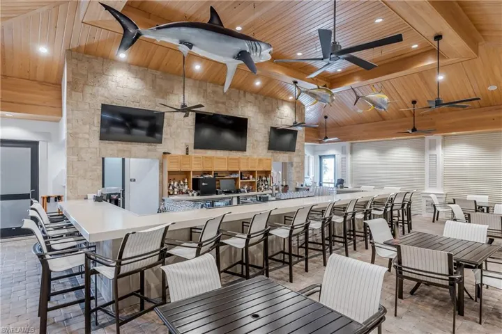 Dining area with a wood ceiling with exposed beams, a ceiling fan, recessed lighting, and a towering ceiling