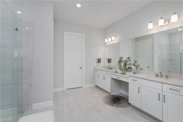 Full bathroom featuring vanity, tiled shower, and recessed lighting