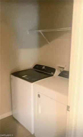 Laundry room featuring tile patterned floors and washing machine and clothes dryer