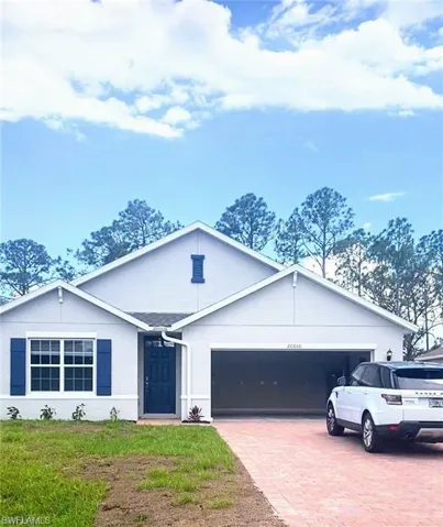Single story home with decorative driveway, a garage, stucco siding, and a front lawn