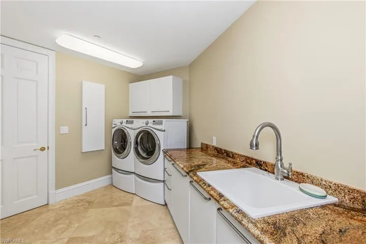 Laundry room with cabinet space, independent washer and dryer, and light tile patterned floors
