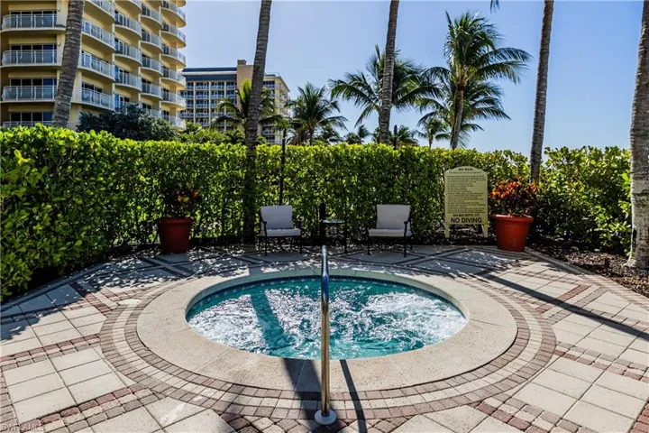 View of pool with a hot tub and a patio area