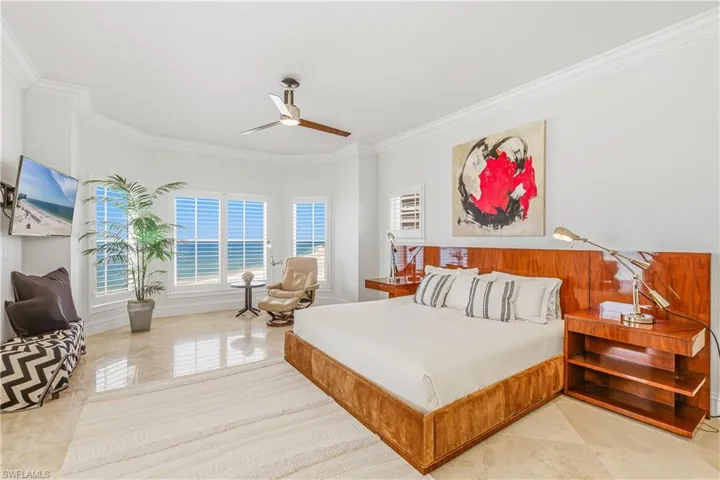 Primary Bedroom with ornamental molding, ceiling fan, and light tile patterned floors