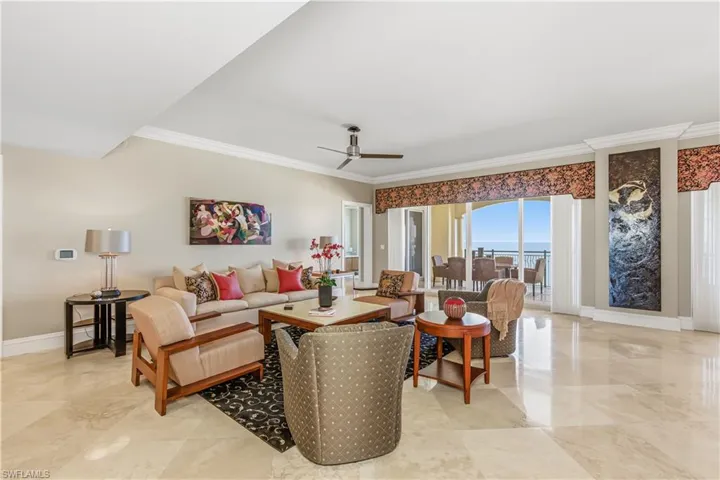 Living area featuring a ceiling fan and ornamental molding