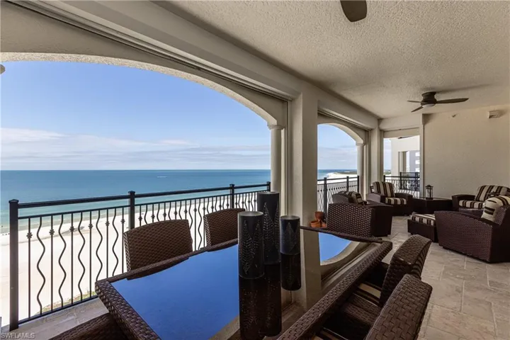 View of patio with outdoor dining space, an outdoor living space, view of water and beach, and ceiling fan