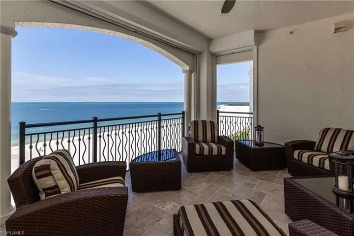 Balcony featuring an outdoor living space and view of water and beach
