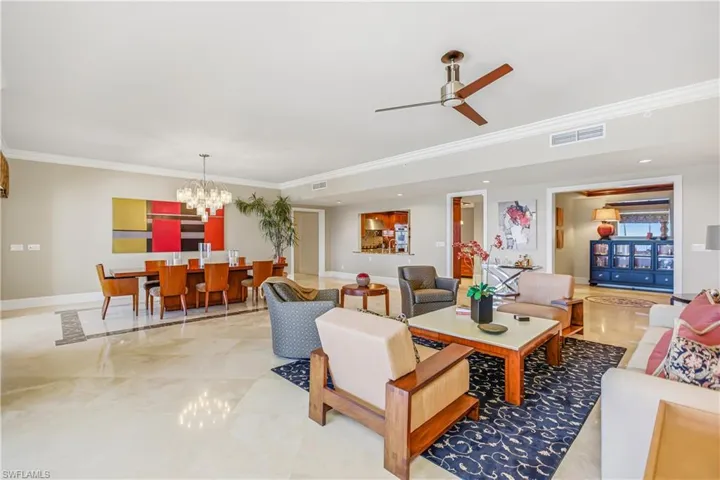 Living area with ornamental molding, a chandelier, and a ceiling fan