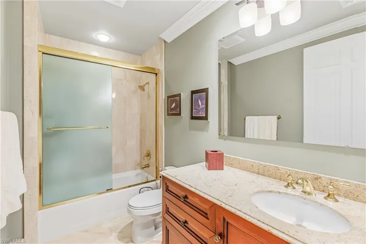 4th Full bathroom featuring enclosed tub / shower combo, vanity, ornamental molding, and light tile patterned floors