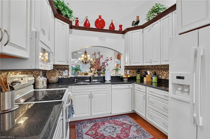 Kitchen features large double sink, soft close drawers, black granite countertops