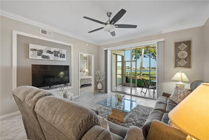 Living room with ceiling fan and ornamental molding