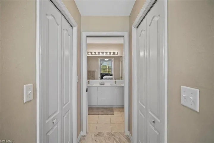 Hall with light tile patterned flooring and sink