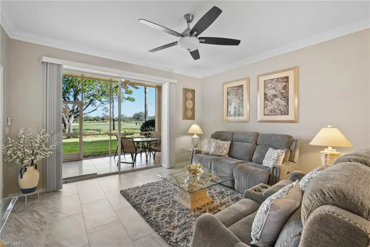 Living room featuring ceiling fan and ornamental molding