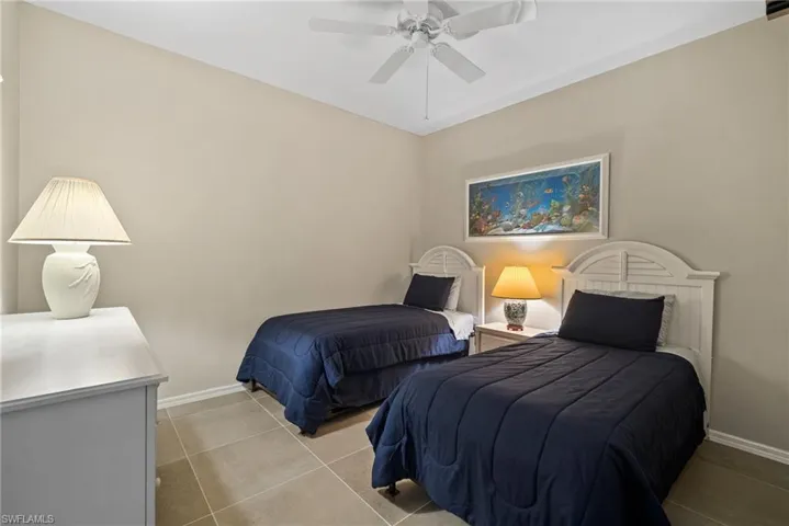 Bedroom with ceiling fan and light tile patterned flooring