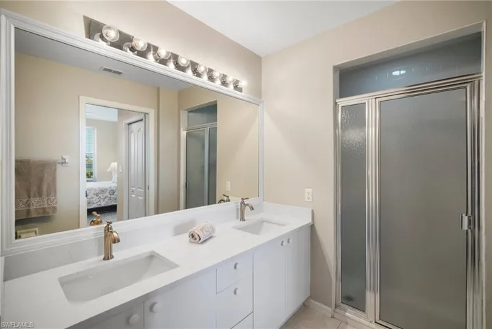 Bathroom featuring tile patterned flooring, vanity, and walk in shower