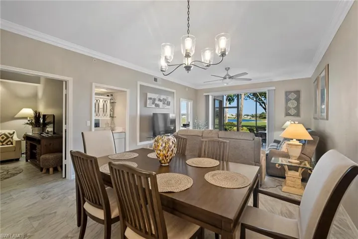 Dining space featuring ceiling fan with notable chandelier and ornamental molding
