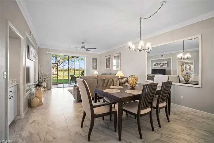 Dining space featuring ceiling fan with notable chandelier and ornamental molding