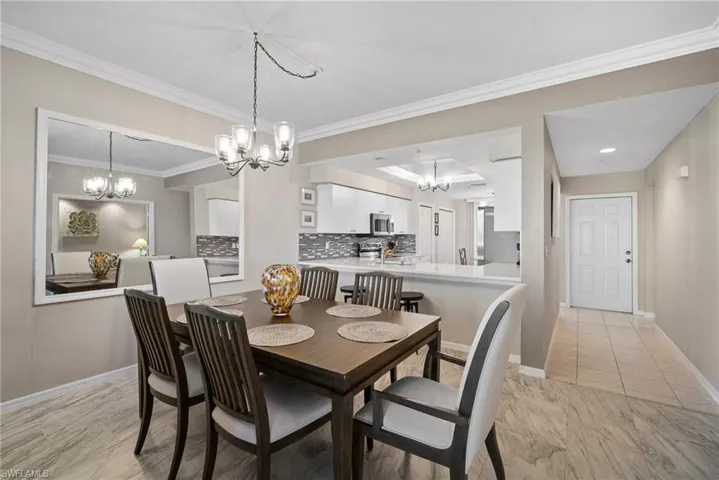 Dining area with a chandelier, ornamental molding, and sink
