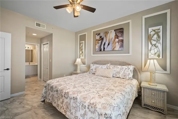 Bedroom with ensuite bathroom, ceiling fan, and a closet