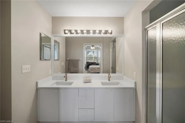 Bathroom with ceiling fan, vanity, and an enclosed shower