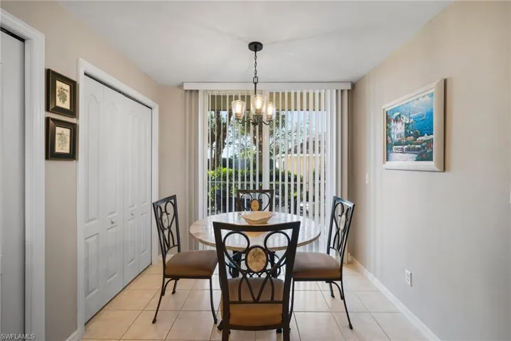 Tiled dining space featuring a notable chandelier