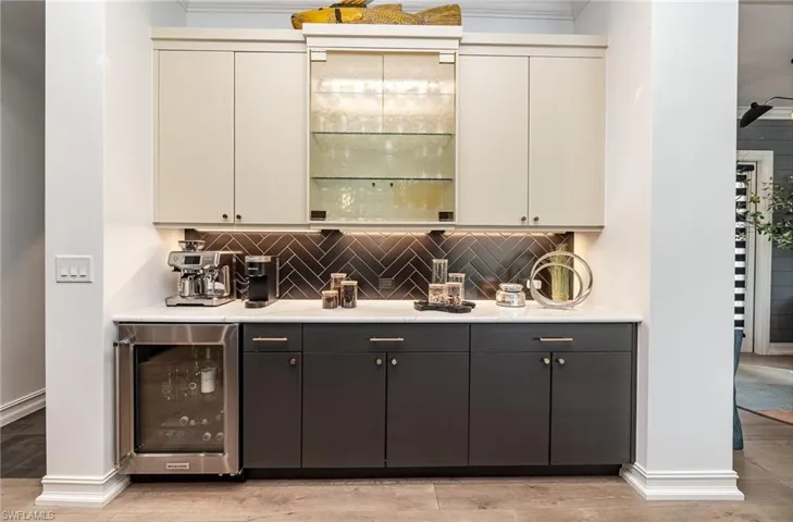 Bar featuring cream cabinets, beverage cooler, light hardwood / wood-style flooring, and tasteful backsplash