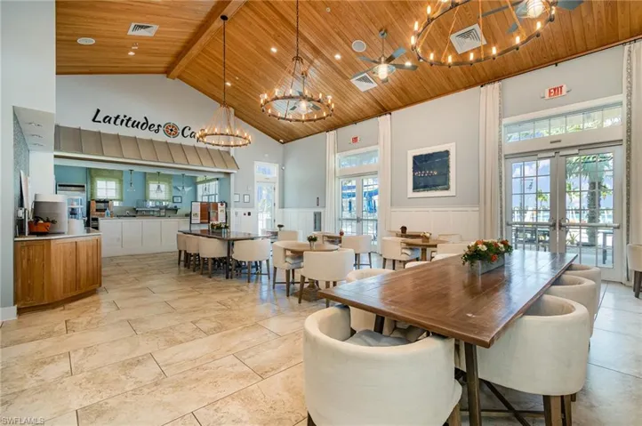 Dining space featuring french doors, beamed ceiling, wooden ceiling, a chandelier, and high vaulted ceiling