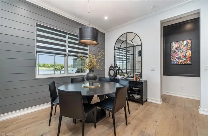 Dining room featuring wooden walls, light hardwood / wood-style floors, and crown molding