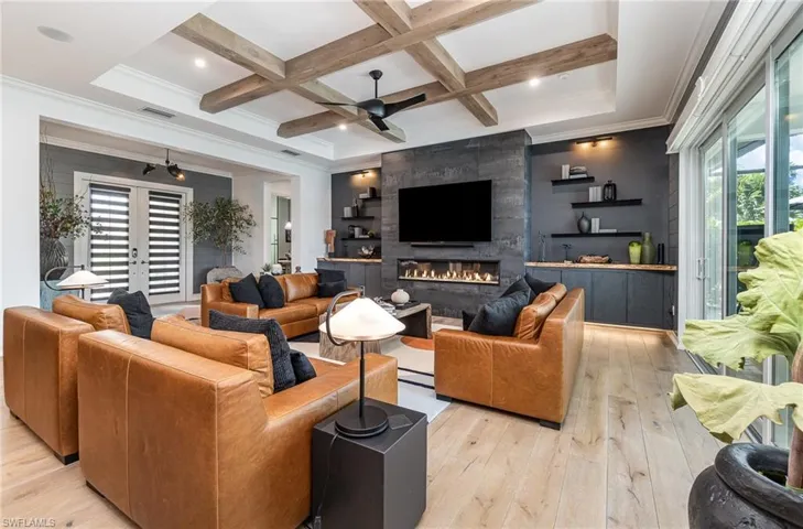 Living room with light wood-type flooring, coffered ceiling, beamed ceiling, and plenty of natural light