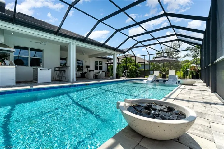View of pool with ceiling fan, a patio, and a lanai