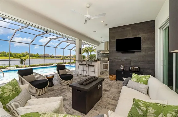 View of patio / terrace featuring glass enclosure, area for grilling, a water view, an outdoor hangout area, and ceiling fan