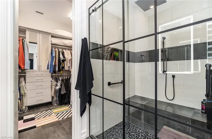 Bathroom with a shower with door and tile patterned floors