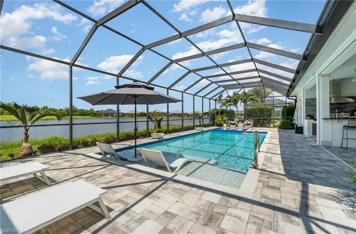 View of pool featuring a patio, a water view, and a lanai