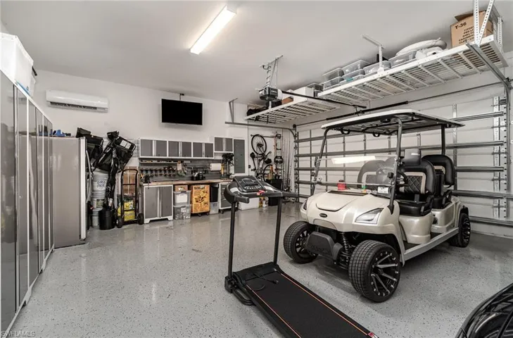 Garage featuring a wall mounted air conditioner and a workshop area
