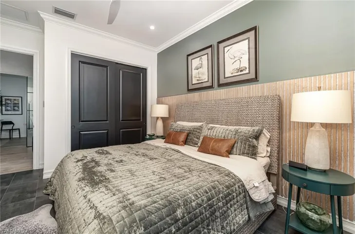 Bedroom with ceiling fan, a closet, crown molding, and dark wood-type flooring