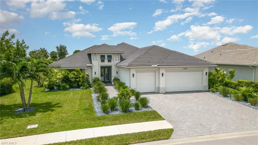 View of front of home with a garage and a front lawn