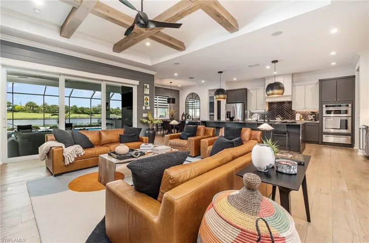 Living room featuring light hardwood / wood-style flooring, ornamental molding, beamed ceiling, and coffered ceiling