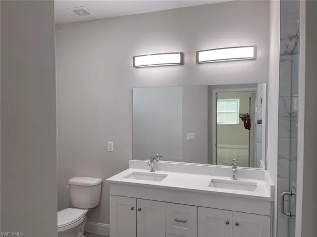 Bathroom with dual vanity and toilet